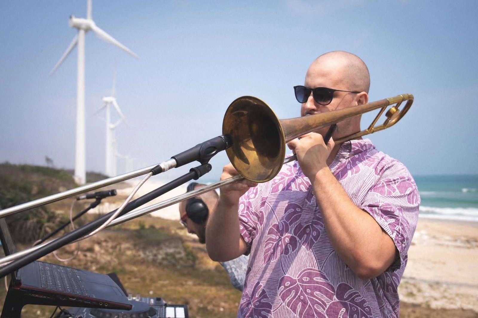 Matt Waters playing trombone on stage at an outdoor gig