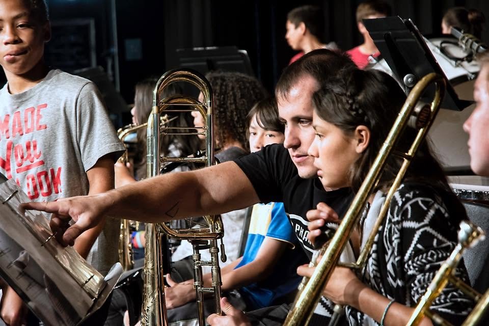 Matt Waters coaching a youth trombone section in rehearsal